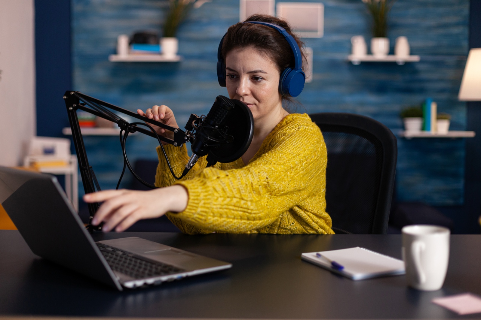 Creator recording at a laptop with a microphone