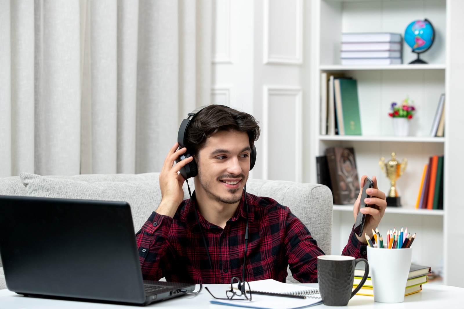 Creator checking a phone while wearing headphones