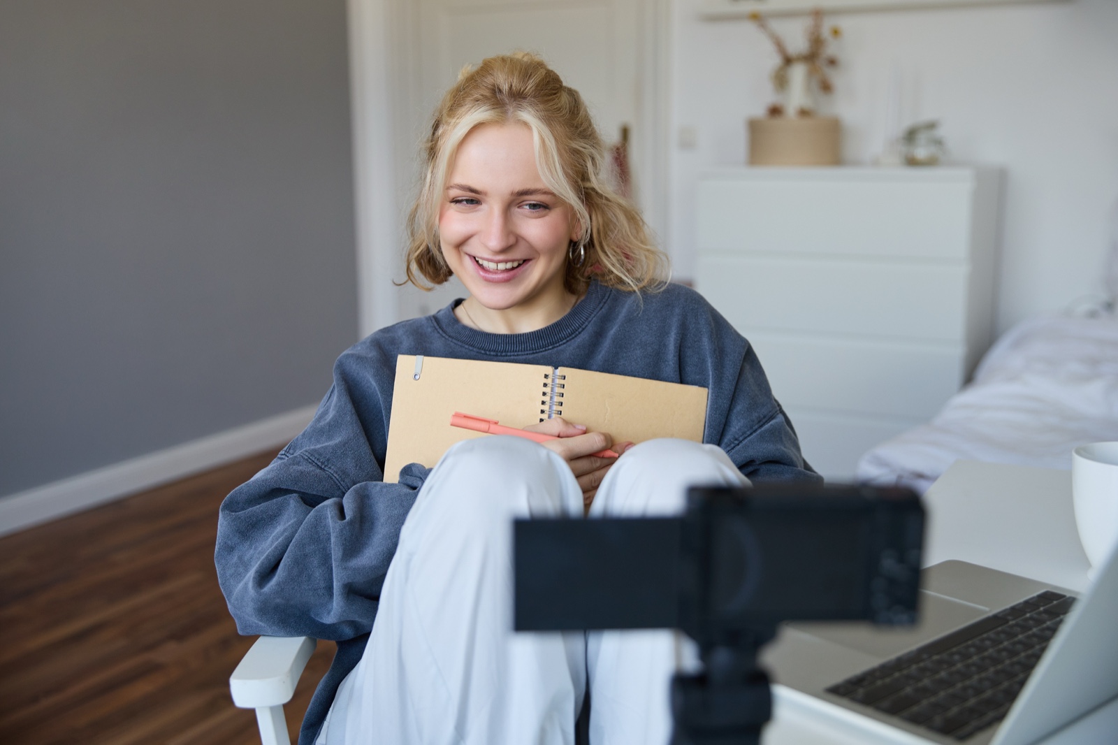 Creator filming at a desk with a notebook