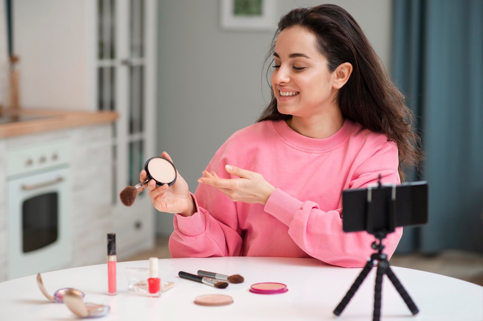 Creator showing a powder compact while filming at a table