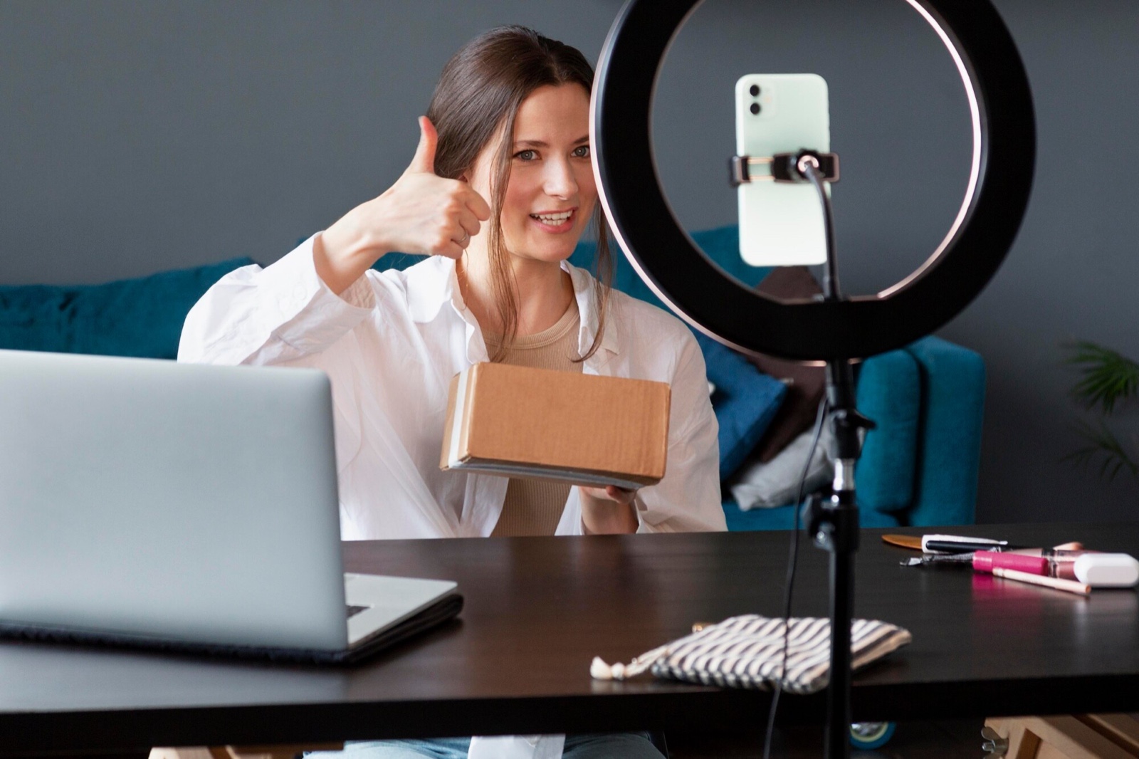 Creator giving a thumbs up while holding a parcel on camera